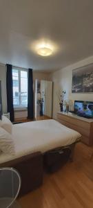 - une chambre avec un grand lit et une télévision à écran plat dans l'établissement Bridgestreet Le Marais - les halles, à Paris