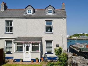 a white house with a white door and windows at Providence Cottage in Turnchapel