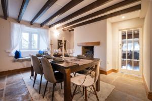 a dining room with a wooden table and chairs at Peep-O-Day-Stylish 4bedroom cottage with Dale view in Feetham