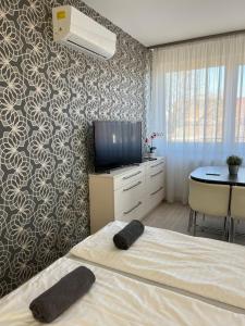a bedroom with a bed and a tv and a table at Hatvan Central Apartment in Debrecen