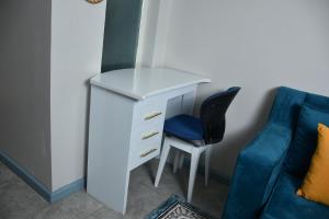 un escritorio con una silla azul junto a un sofá azul en Tsavo Studio Lavish Home-307 en Nairobi
