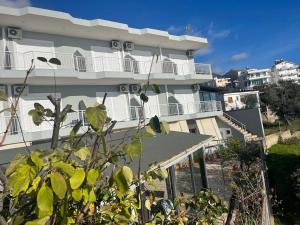 a white building with balconies on the side of it at La Maroja View Hotel in Dhërmi