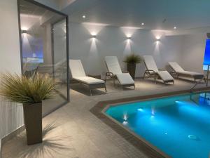 a swimming pool in a room with chairs at Inselresidenz Strandburg Apartment 209 in Juist