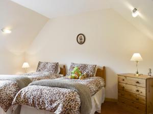 a bedroom with two beds and a dresser with lamps at The Stables - Uk5532 in Kepculloch
