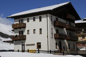 a large white building with balconies in the snow at Garni Gimea in Livigno