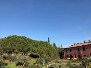 een huis en een heuvel met bomen en een gebouw bij Sunset house in Rosignano Marittimo