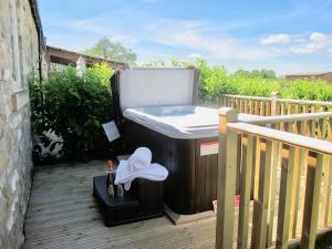 a hot tub on a deck with a sink at Sykelands Cottage in Ravensworth