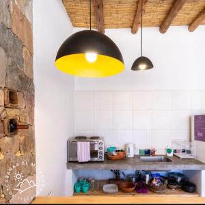 una cocina con una luz amarilla colgada del techo en Cabañas El Mirador de Tilcara en Tilcara