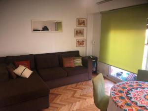 a living room with a couch and a green wall at Acogedor departamento en Caballito in Buenos Aires