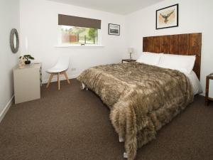 a bedroom with a large bed and a chair at Rosdail in Inverinate