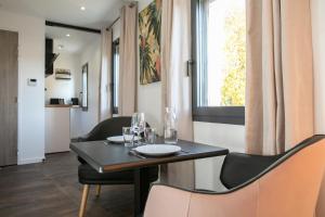 a dining room with a table and chairs and a window at Le Maleville - Appartements de Standing in Périgueux