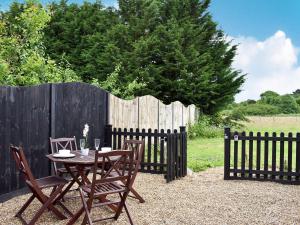 a wooden table and chairs with a fence at Elm - Uk11991 in Greenhill