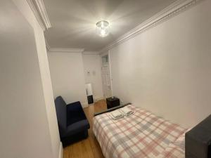a bedroom with a bed and a blue chair at Cozy Double Room in Marylebone-Paddington #room name is amsterdam# in London