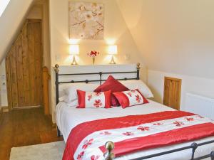 a bedroom with a large bed with red pillows at Half Moon in Herstmonceux