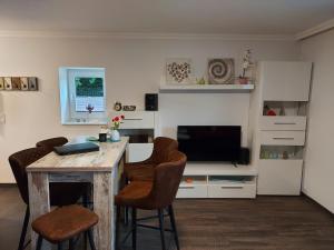 a living room with a desk with a television and chairs at Gästequartier Schlummerkasten in Sievern