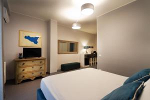 1 dormitorio con 1 cama y vestidor con TV en Isula, en Palermo