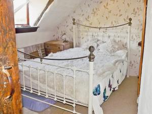 a bedroom with a white bed in a attic at The Hideaway Cottage in Gloucester
