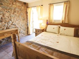 a bedroom with a bed and a stone wall at Stable Barn - Hw7591 in Bettws-yn-Rhôs