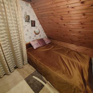 a small bedroom with a bed in a wooden room at Planinska kućica Svetlana Zlatibor in Ribnica