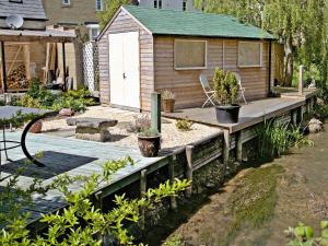 a garden with a wooden deck and a shed at Stratton Mill in Cirencester