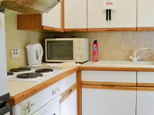 eine Küche mit einem Herd und einer Mikrowelle in der Unterkunft Strathisla in Largs