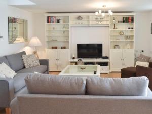 a living room with a couch and a tv at The Old Smithy in Kea