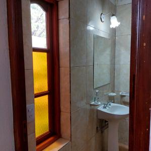 a bathroom with a sink and a mirror and a window at Hostal killari in Cafayate