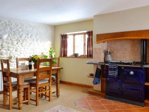 cocina con mesa y fogones en Grange Farm Cottage, en Barton in the Clay