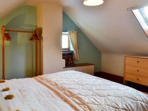 的住宿－格蘭奇農莊小屋，卧室配有白色的床和窗户。