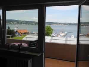een uitzicht op een haven vanuit een kamer met 2 ramen bij Ferienwohnung Grob "Seeblick" in Konstanz