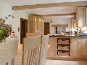 uma cozinha com armários de madeira e uma bancada em The Oak em Newchurch