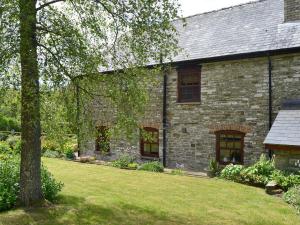 una antigua casa de piedra con un patio en The Oak, en Newchurch