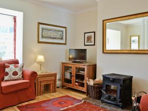 a living room with a fireplace and a television at Dunardry View in Lochgilphead