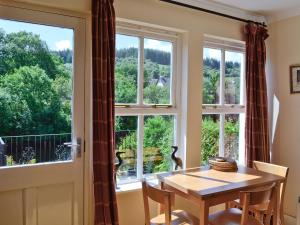 een eetkamer met een tafel en een raam bij Dunardry View in Lochgilphead
