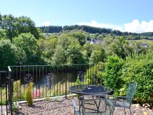 a patio with a table and chairs and a fence at Dunardry View in Lochgilphead