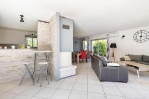 uma cozinha e sala de estar com um sofá e uma mesa em villa vigneronne em Saint-Hilaire-de-Brethmas
