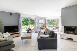 uma sala de estar com um sofá e uma lareira em villa vigneronne em Saint-Hilaire-de-Brethmas