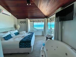 1 dormitorio con bañera, cama y bañera en Pousada Maracabana Spa en Porto De Galinhas