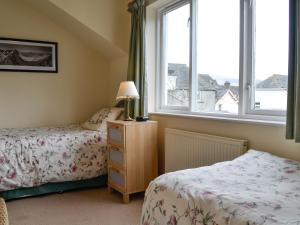 a bedroom with two beds and a window at Bay Tree in Keswick