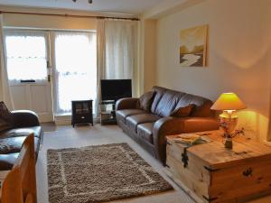 sala de estar con sofá de cuero y mesa de centro en Beech Cottage, en Windermere