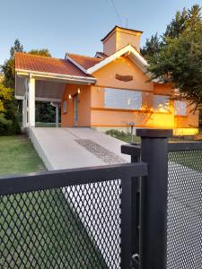 una casa con una valla delante de ella en Casa Naranja en Merlo
