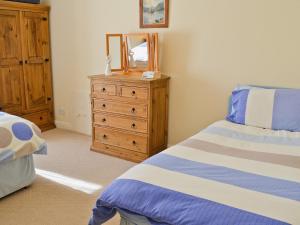 1 dormitorio con cama, tocador y espejo en Beech Cottage, en Windermere