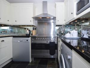 a kitchen with a stainless steel stove and white cabinets at 8 Torwood Gables in Torquay