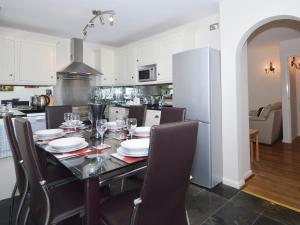 a kitchen with a dining table with chairs and a kitchen with at 8 Torwood Gables in Torquay
