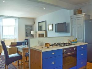 a kitchen with blue cabinets and a stove top oven at St Andrews in Pittenweem
