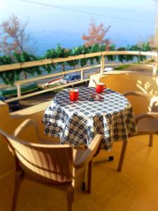 ペスタニにあるApartmani BAKULEのバルコニーの上に赤いカップ2つ付きのテーブル