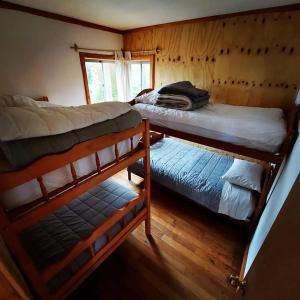 a bedroom with two bunk beds and a window at Cabañas Nativo D'Ko in Carahuo