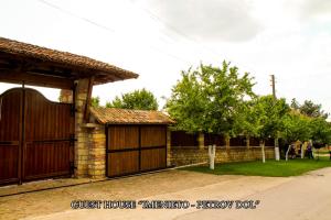 a house with a wooden garage and a fence at Imenieto in Petrovdol