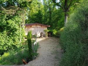 einen Weg, der zu einem Holzschuppen im Garten führt in der Unterkunft LES MATHIEUX la cabane du Parc in Bongheat