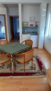 a dining room with a table and chairs and a kitchen at Apartmani BAKULE in Peštani